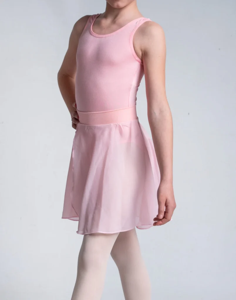 Young dancer wearing a pink leotard, matching ballet skirt and tights.